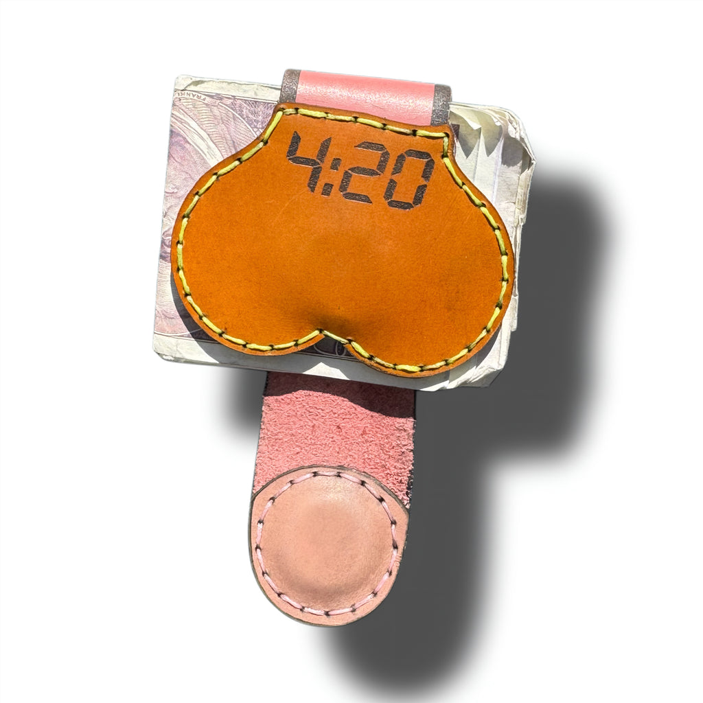 4:20 XL leather money clip holding folded bills, digital clock engraving on the tan front, pink suede strap below