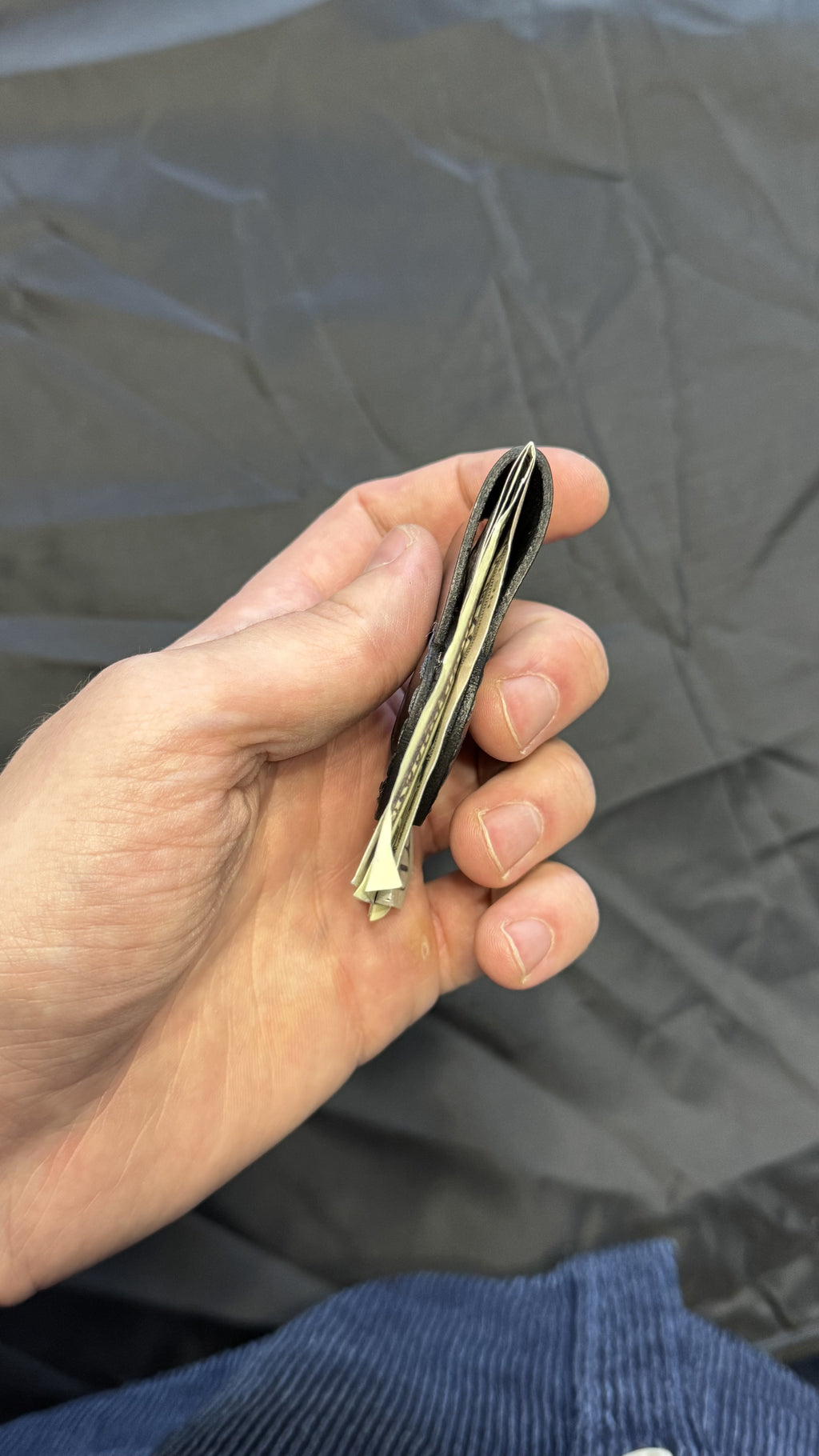 Black leather magnetic money clip, minimalist EDC — in-hand view — Lamamarka