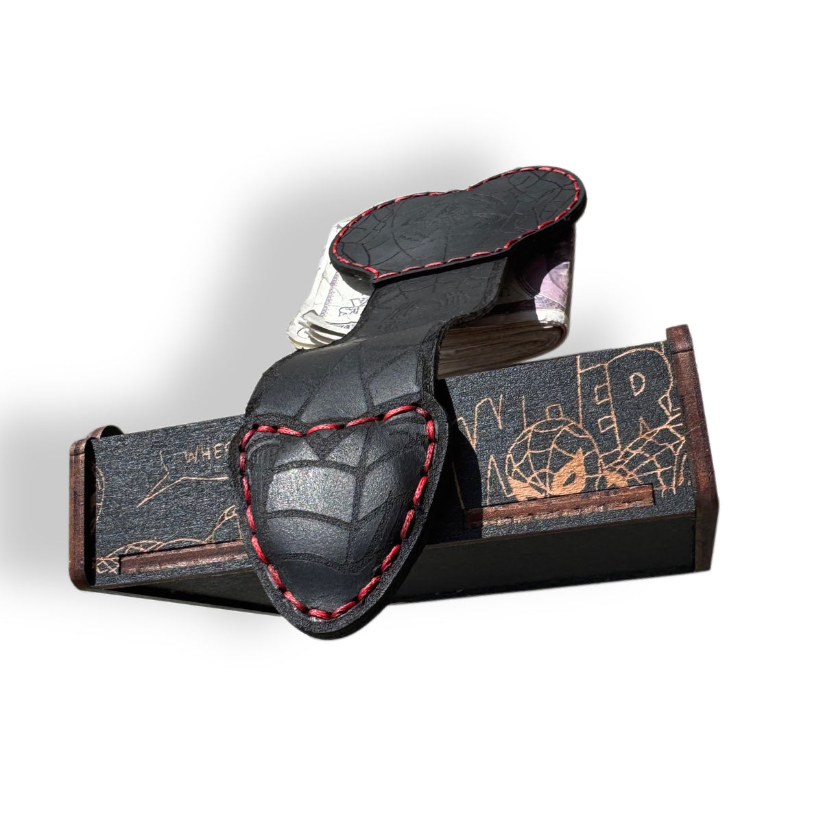 Black leather XL money clip tooled with spider webs, shown full length with cash