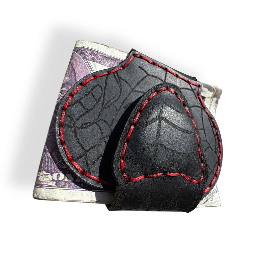 Close-up of red contrast stitching and web tooling on black leather money clip