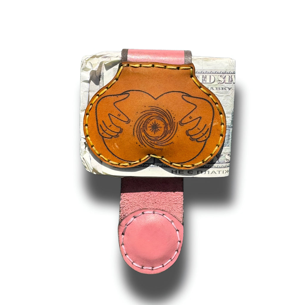 Butt engraved XL leather money clip holding folded cash, tan front with two hands squeezing a booty, pink magnetic strap