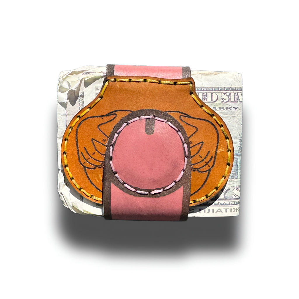 Butt engraved leather money clip closed, pink magnetic strap wrapped over the tan front panel