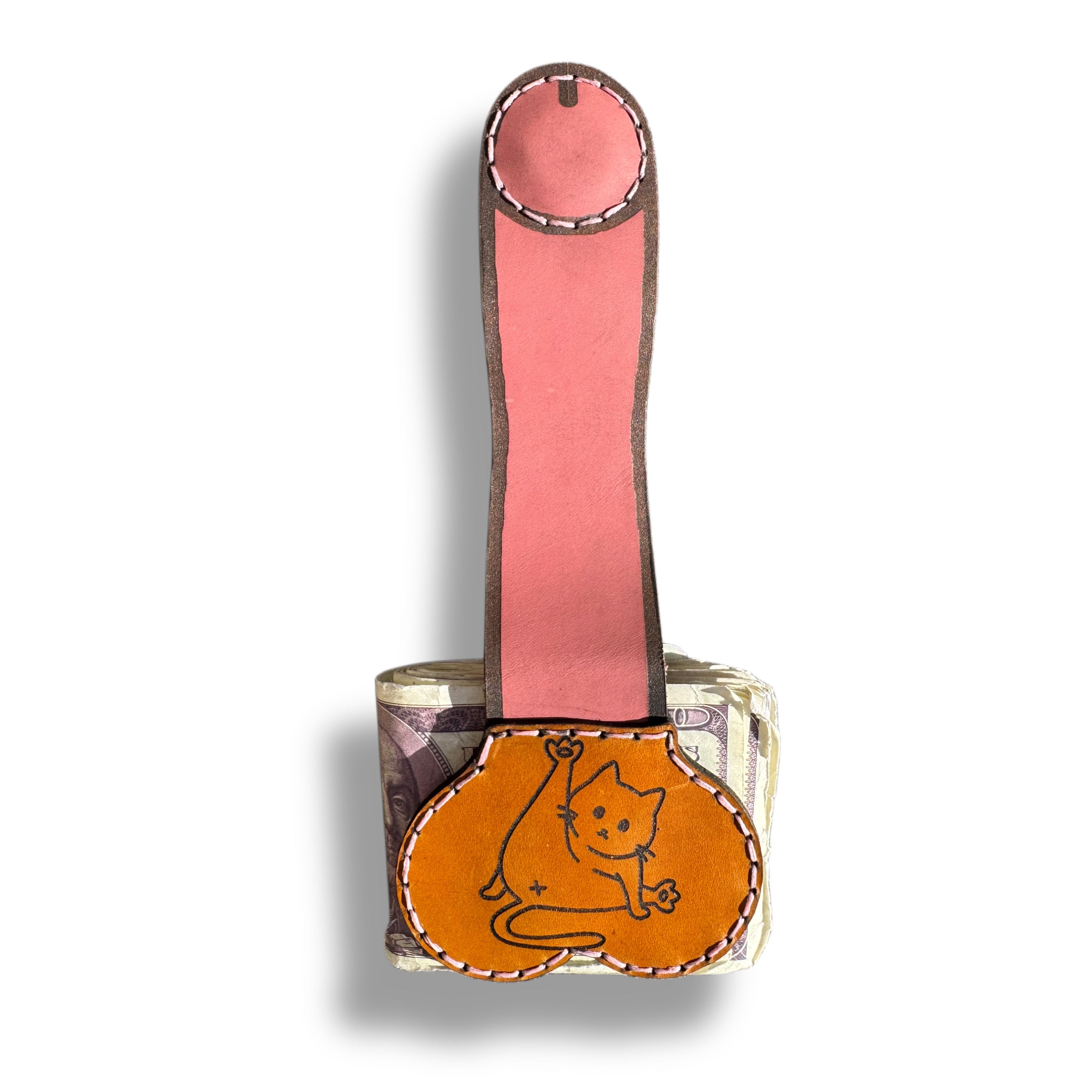Cat person edition XL leather money clip fully extended, long pink strap with a round magnetic tip above the tan pouch on folded cash