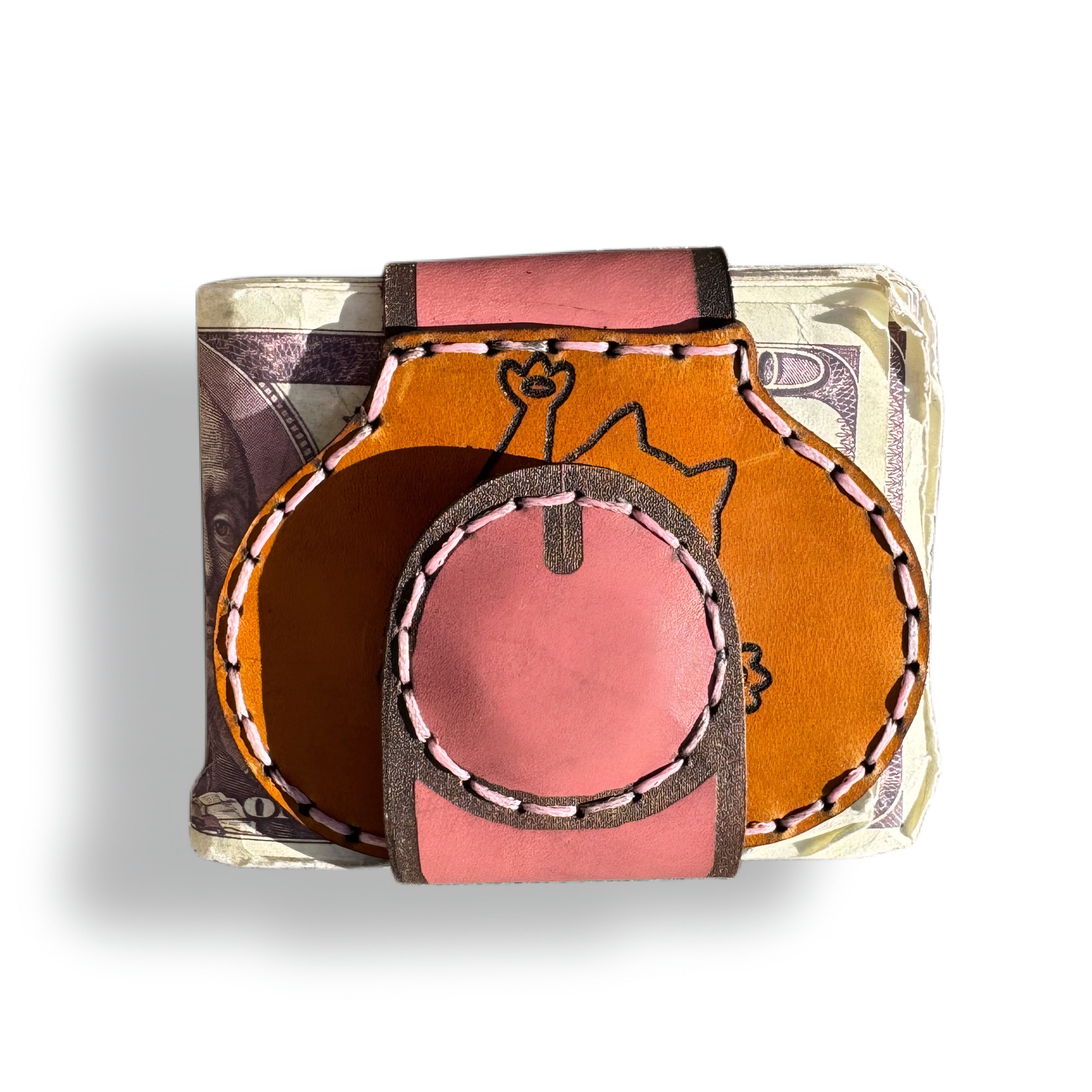 Cat person edition leather money clip closed, round pink magnetic tip on the tan front engraved with a cat holding a flower