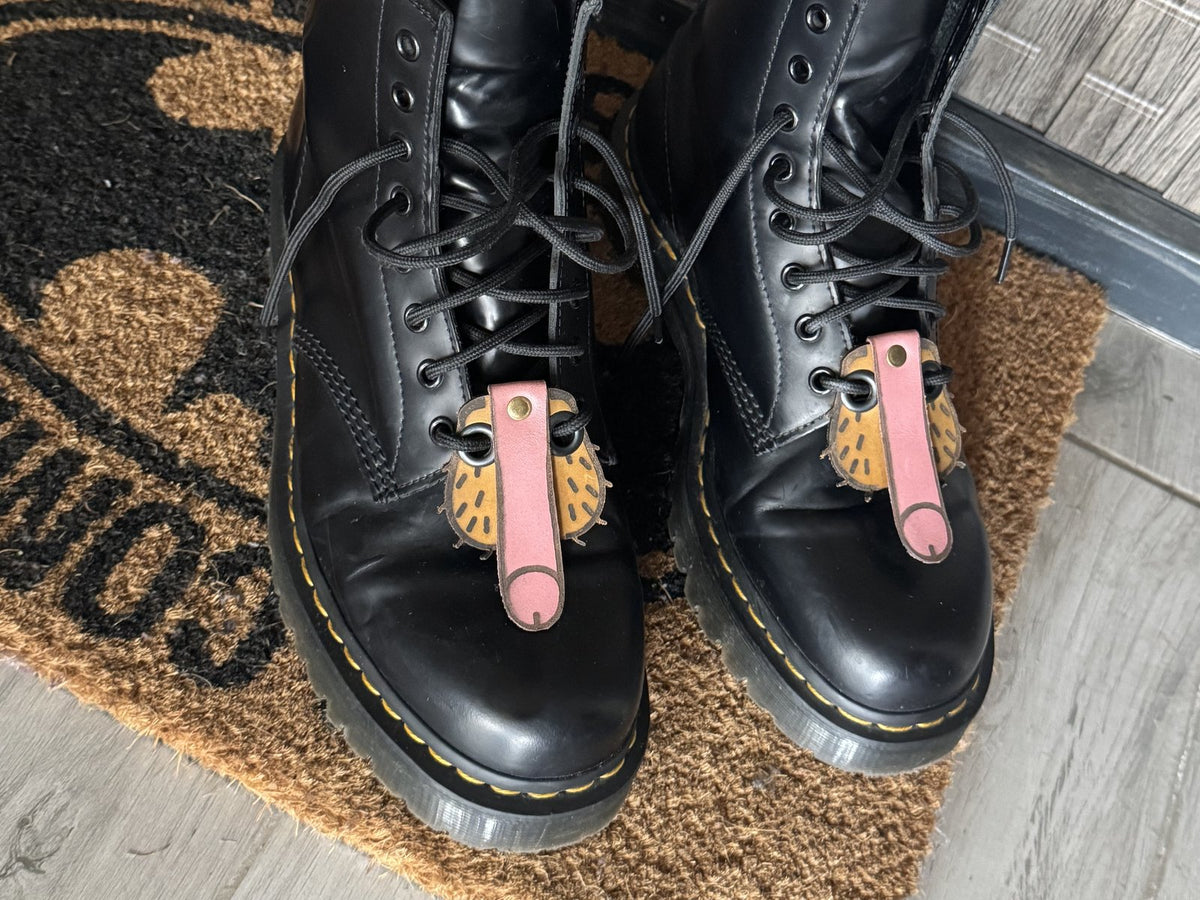 Cheeky engraved leather keychain clipped to black boot laces, Lamamarka