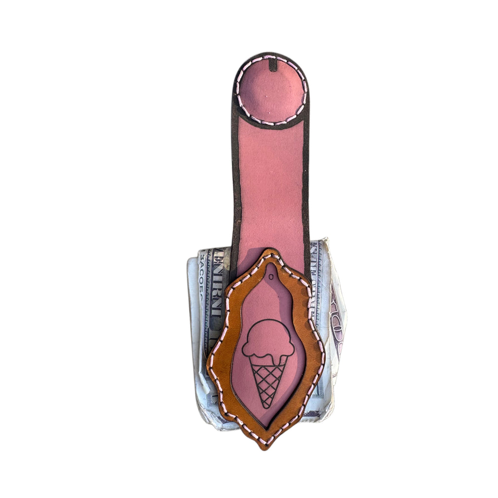 Dessert First money clip extended, long pink strap above tan frame with ice cream cone