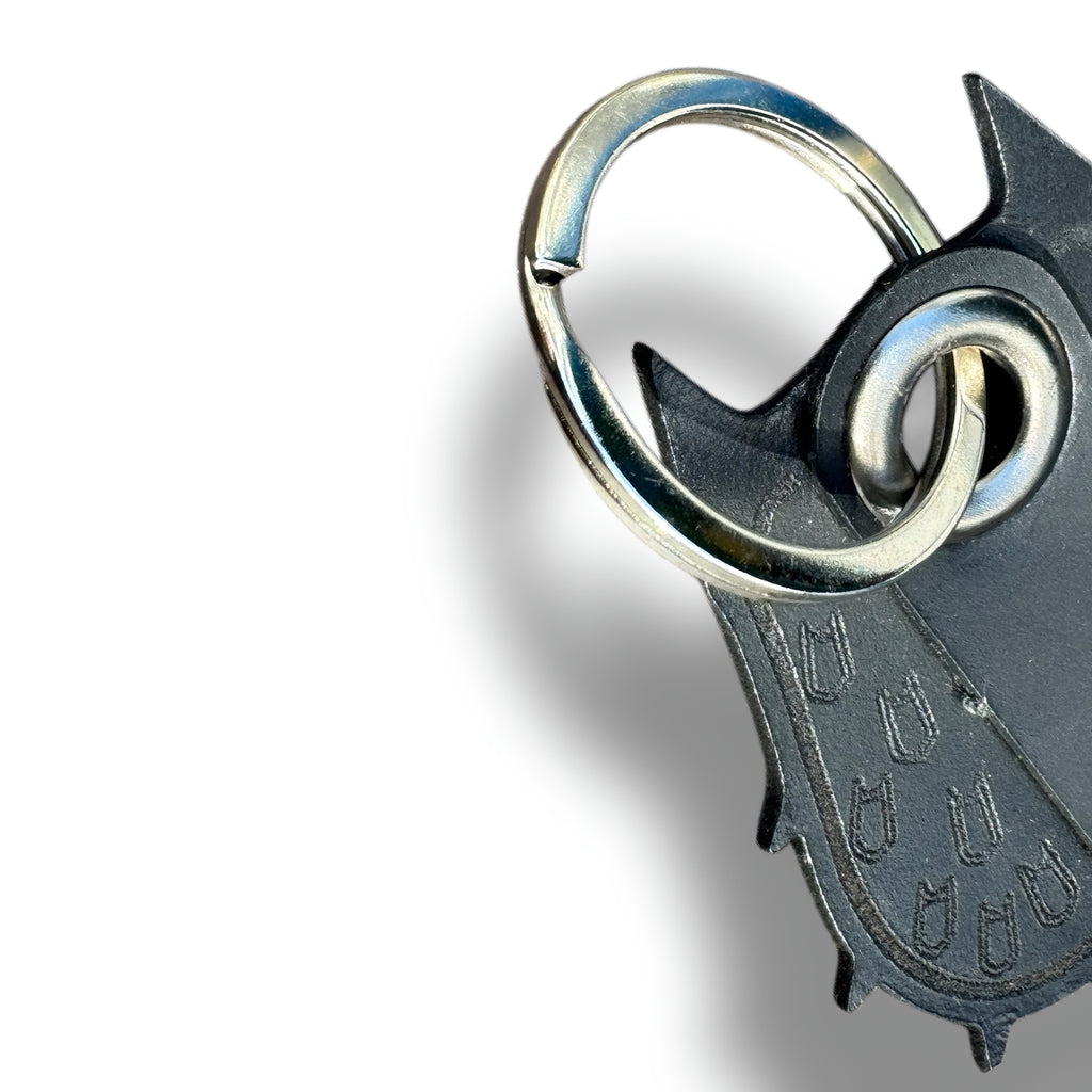 Macro of the steel split ring and eyelet on a handmade black leather bat keychain