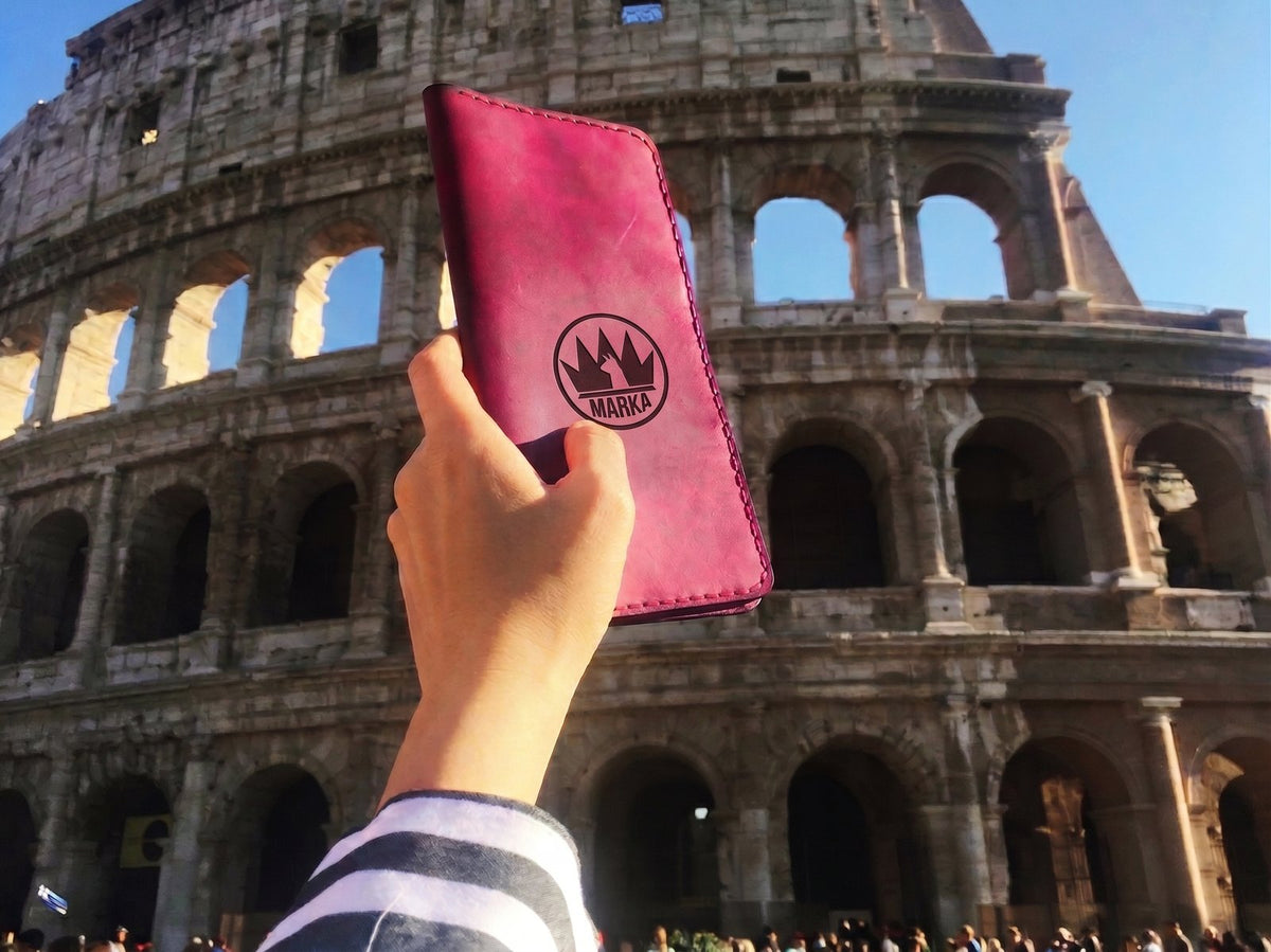 Hand holding a magenta leather wallet at the Colosseum, lifestyle, Lamamarka