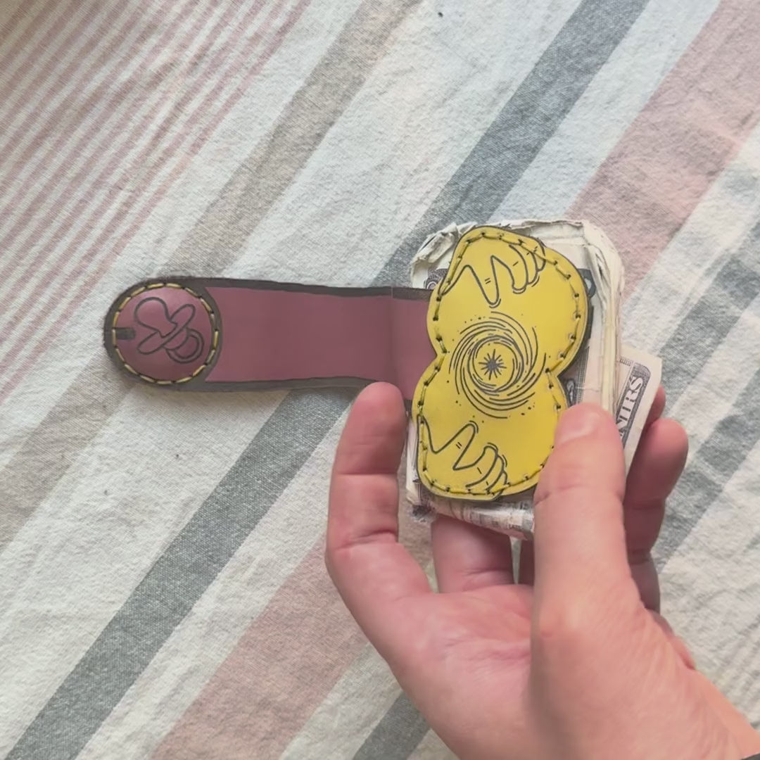 Hand opens and closes the Suck It Up XL money clip, showing both sides