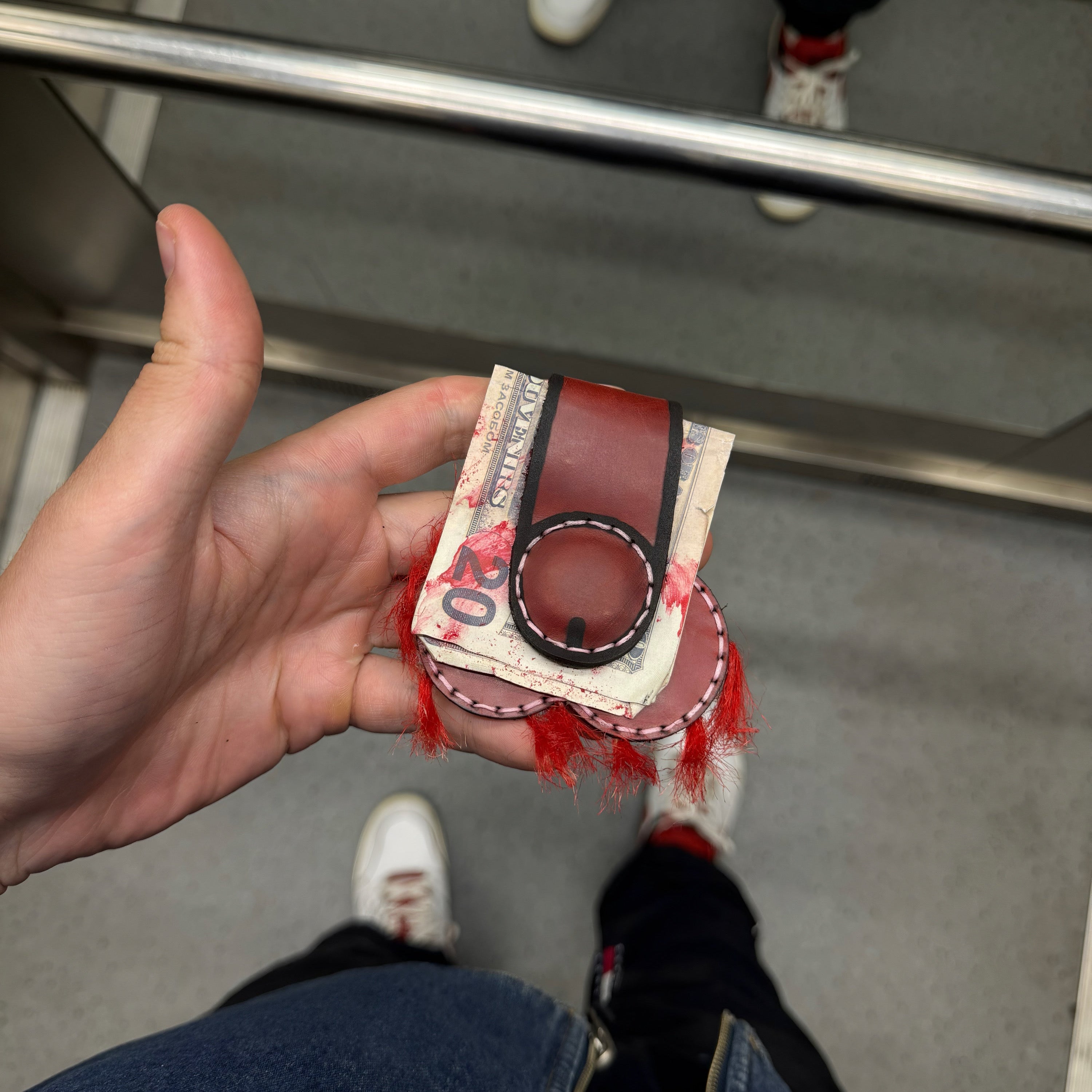 Back of the red leather money clip, magnetic clip holding a folded 20 dollar bill