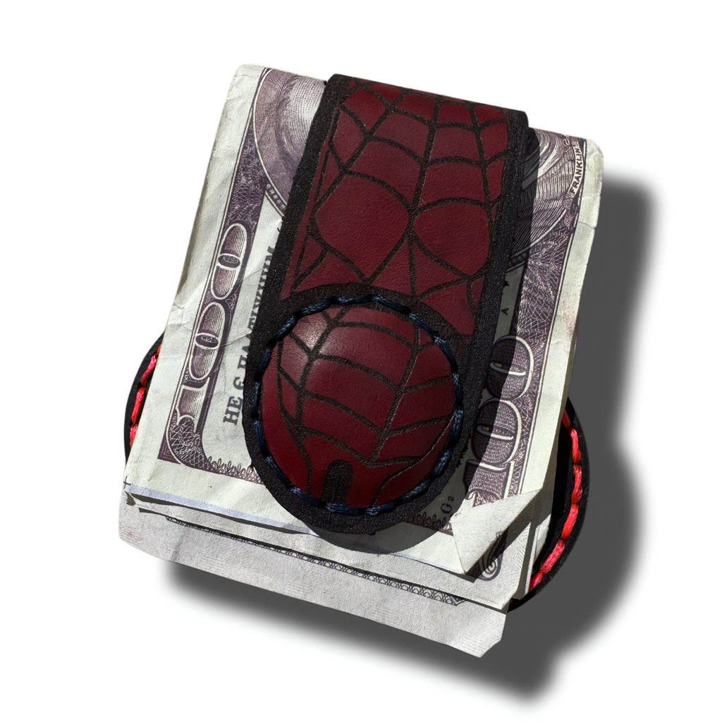 Spider web leather money clip, front view with red engraved web, holding folded cash - Lamamarka