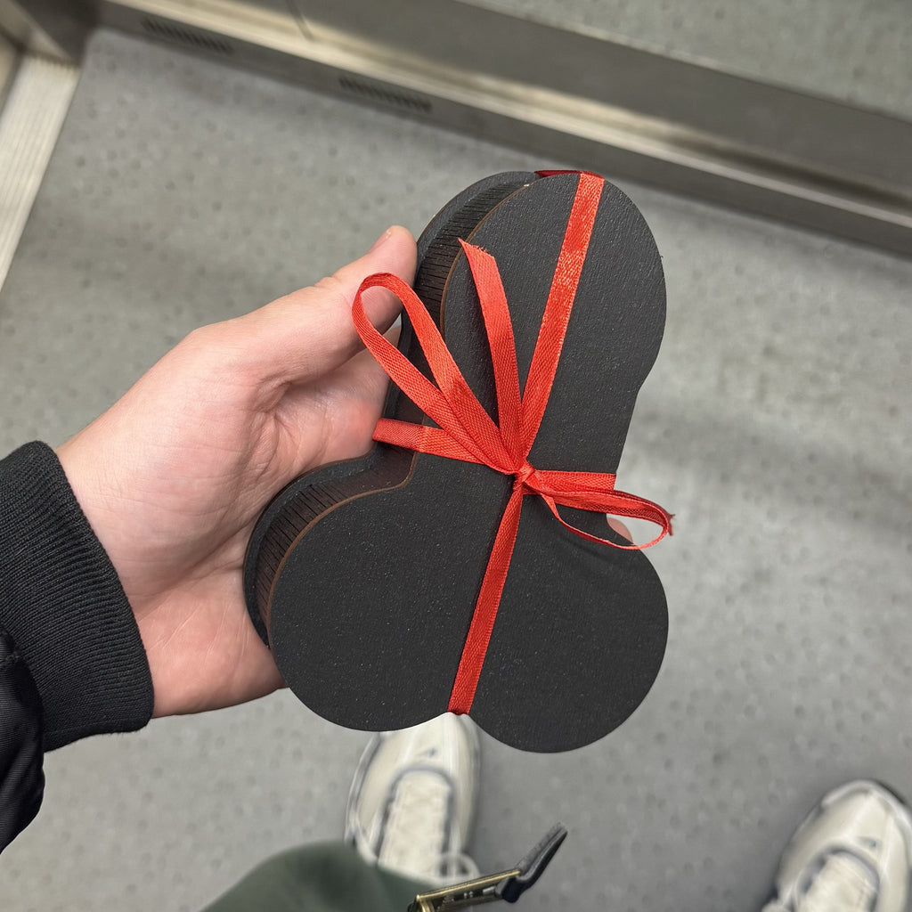 The Package black wooden gift box with red ribbon held in hand